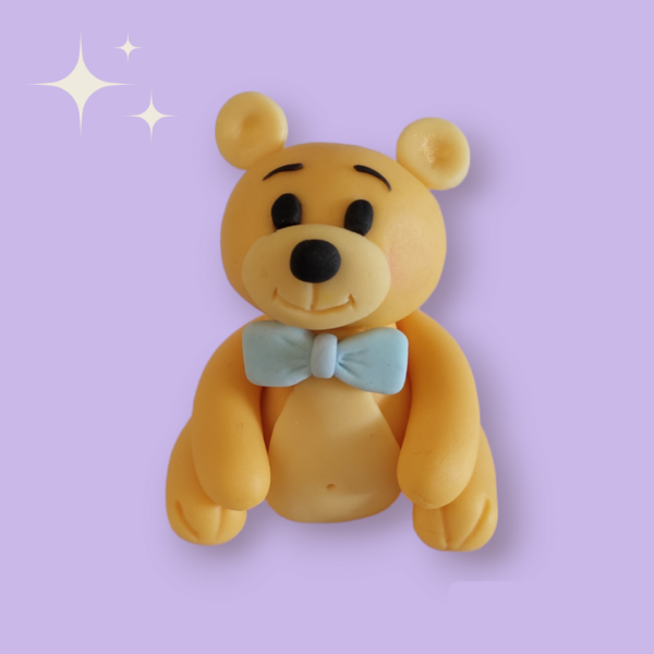 Personnage de décoration à poser sur un cake design représentant le nounours préféré des enfants, portant un noeud papillon autour du cou