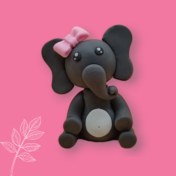 Personnage de décoration à poser sur le cake design représentant un éléphant ou un éléphanteau, de couleur noir avec un noeud papillon rose sur la tête